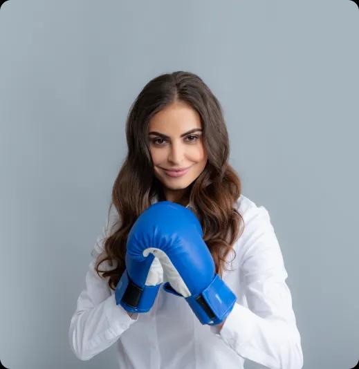 A young woman in a white shirt with blue boxing gloves.